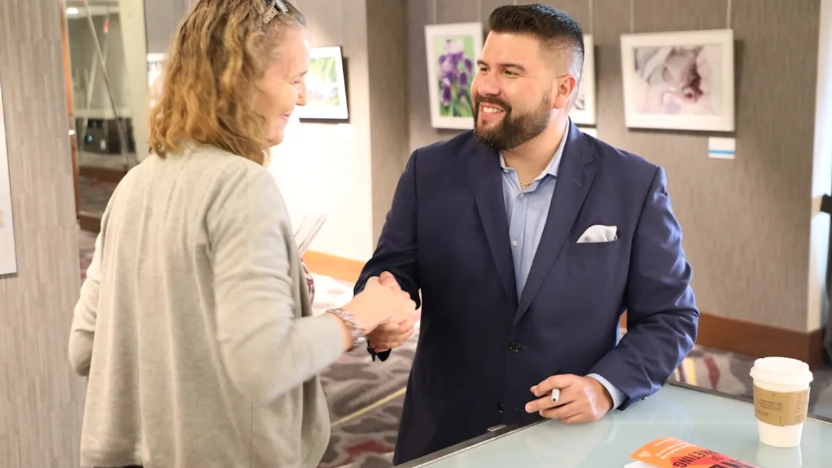 Business owner welcoming a new customer with a handshake